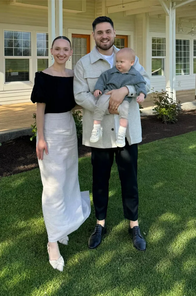 One of the IE Pro Exteriors owners with his wife and baby in front of a white two-story home