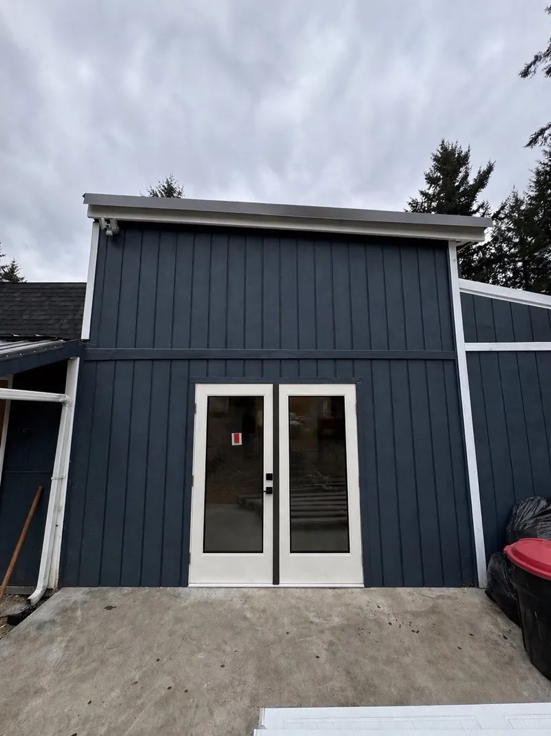 Navy board-and-batten wall with white trim and white French doors